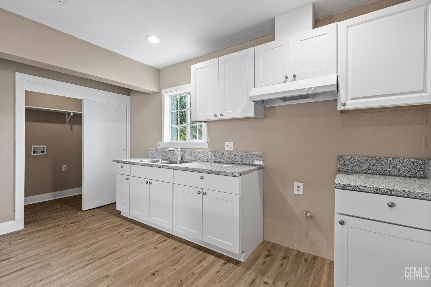 Undisclosed Address Bakersfield, CA 93305 - Photo 14 of 32 a kitchen with granite countertop white cabinets and white appliances