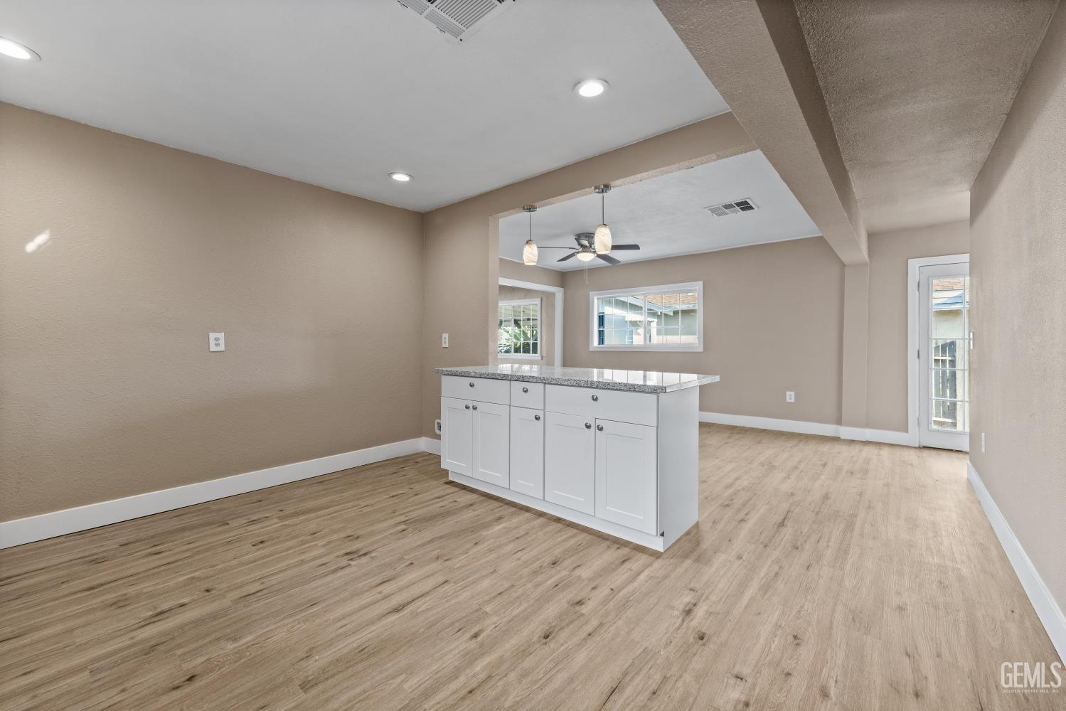 Undisclosed Address Bakersfield, CA 93305 - Photo 16 of 32 an empty room with wooden floor and cabinet