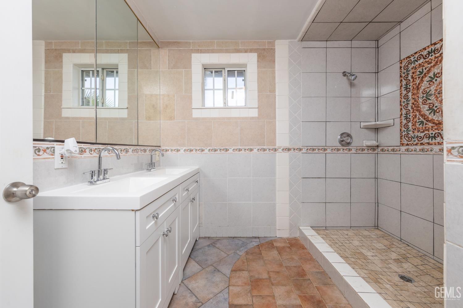 Undisclosed Address Bakersfield, CA 93305 - Photo 19 of 32 a bathroom with a granite countertop sink a shower and a mirror