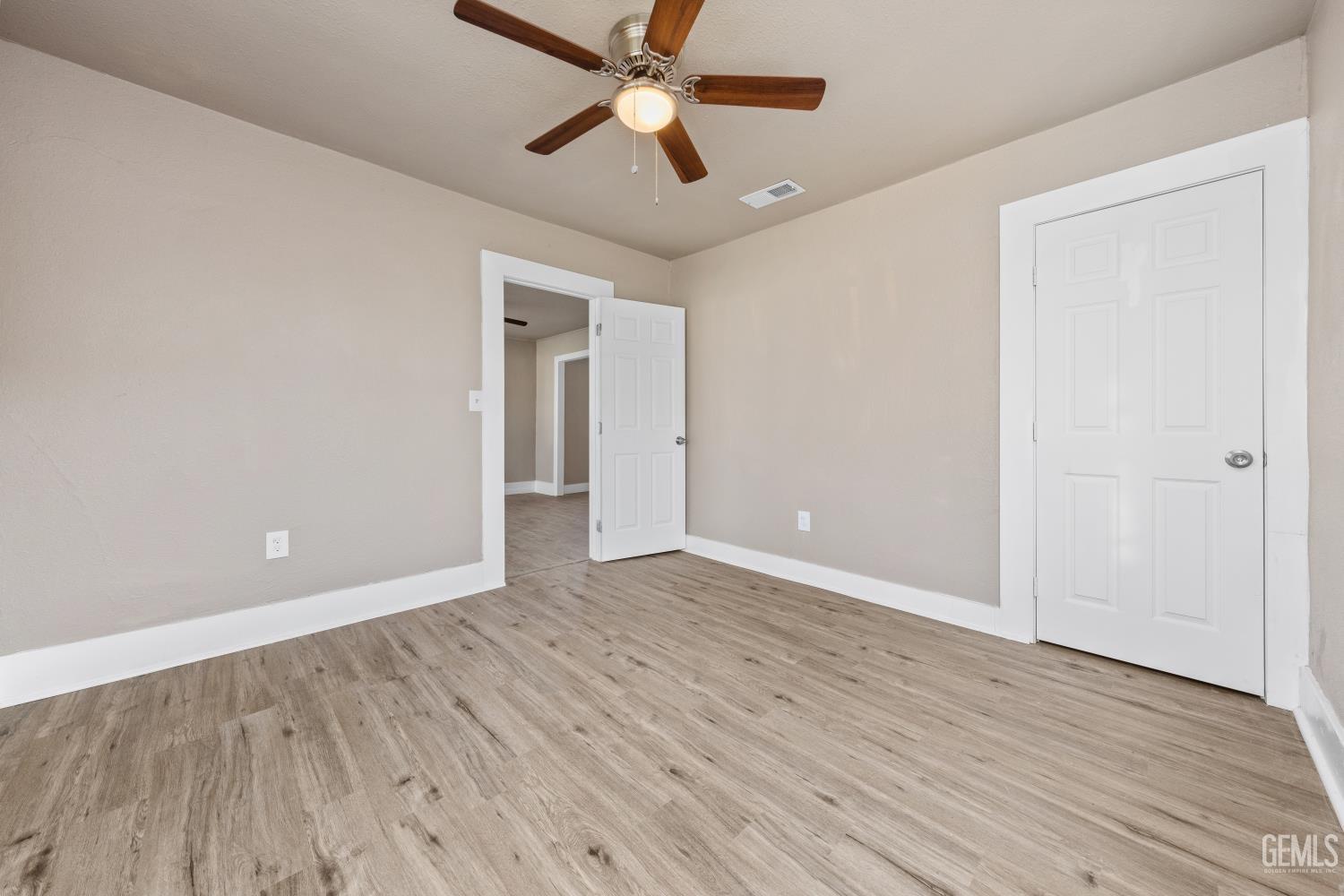 Undisclosed Address Bakersfield, CA 93305 - Photo 26 of 32 an empty room with wooden floor ceiling fan and windows