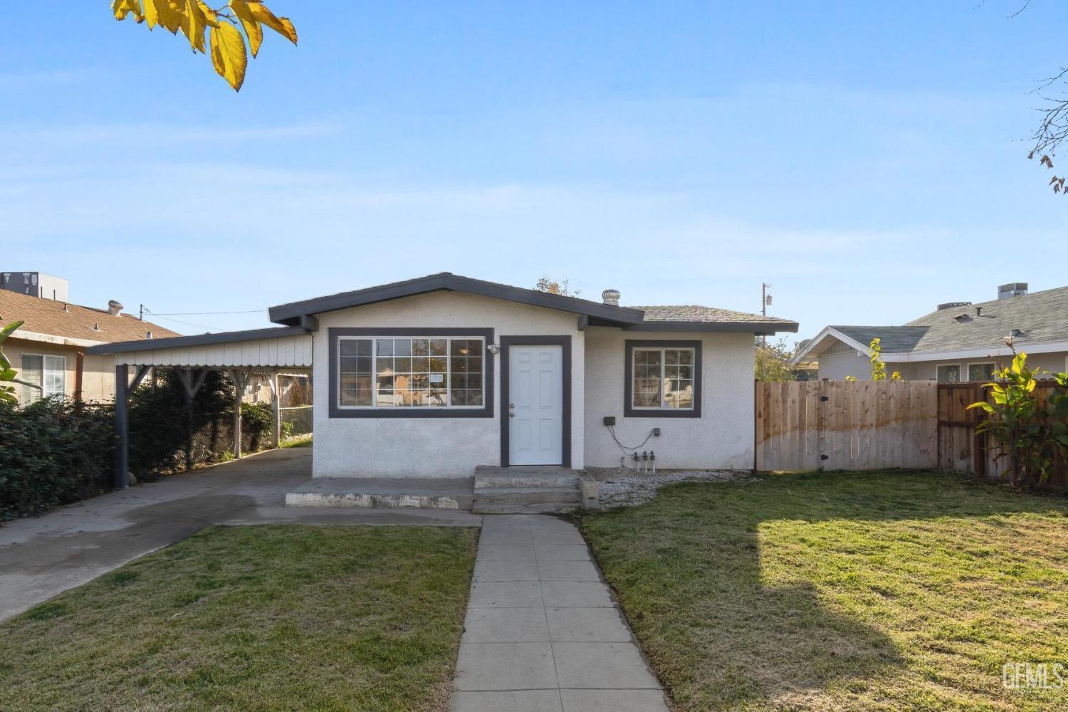 Undisclosed Address Bakersfield, CA 93305 - Photo 4 of 32 a front view of a house with a yard and garage