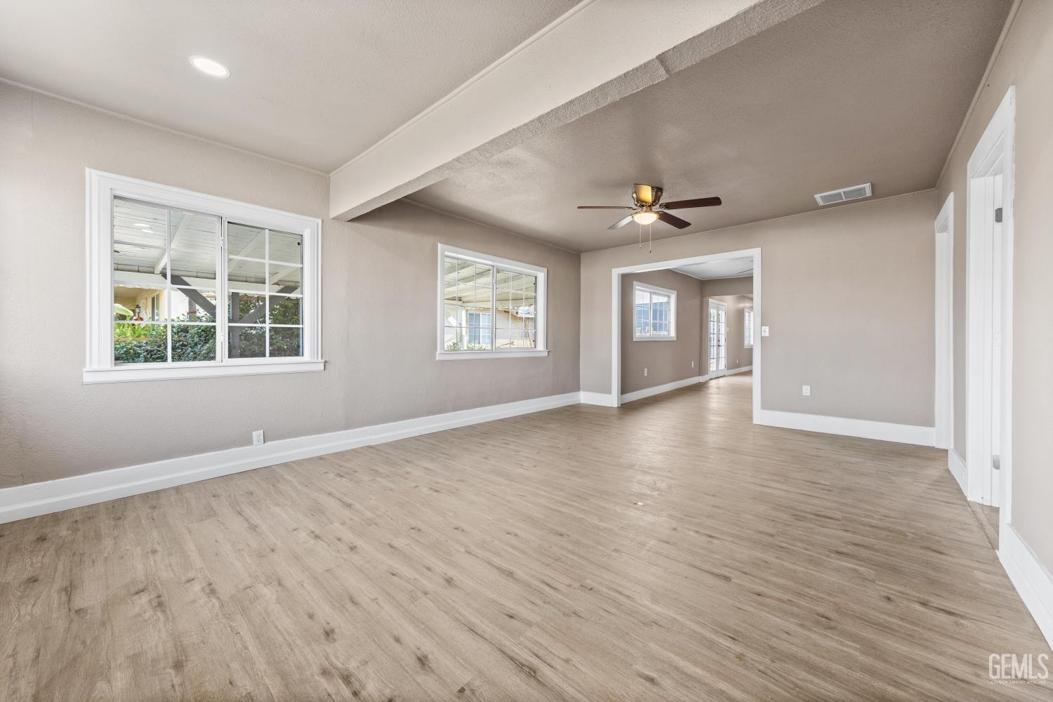 Undisclosed Address Bakersfield, CA 93305 - Photo 5 of 32 an empty room with wooden floor and windows