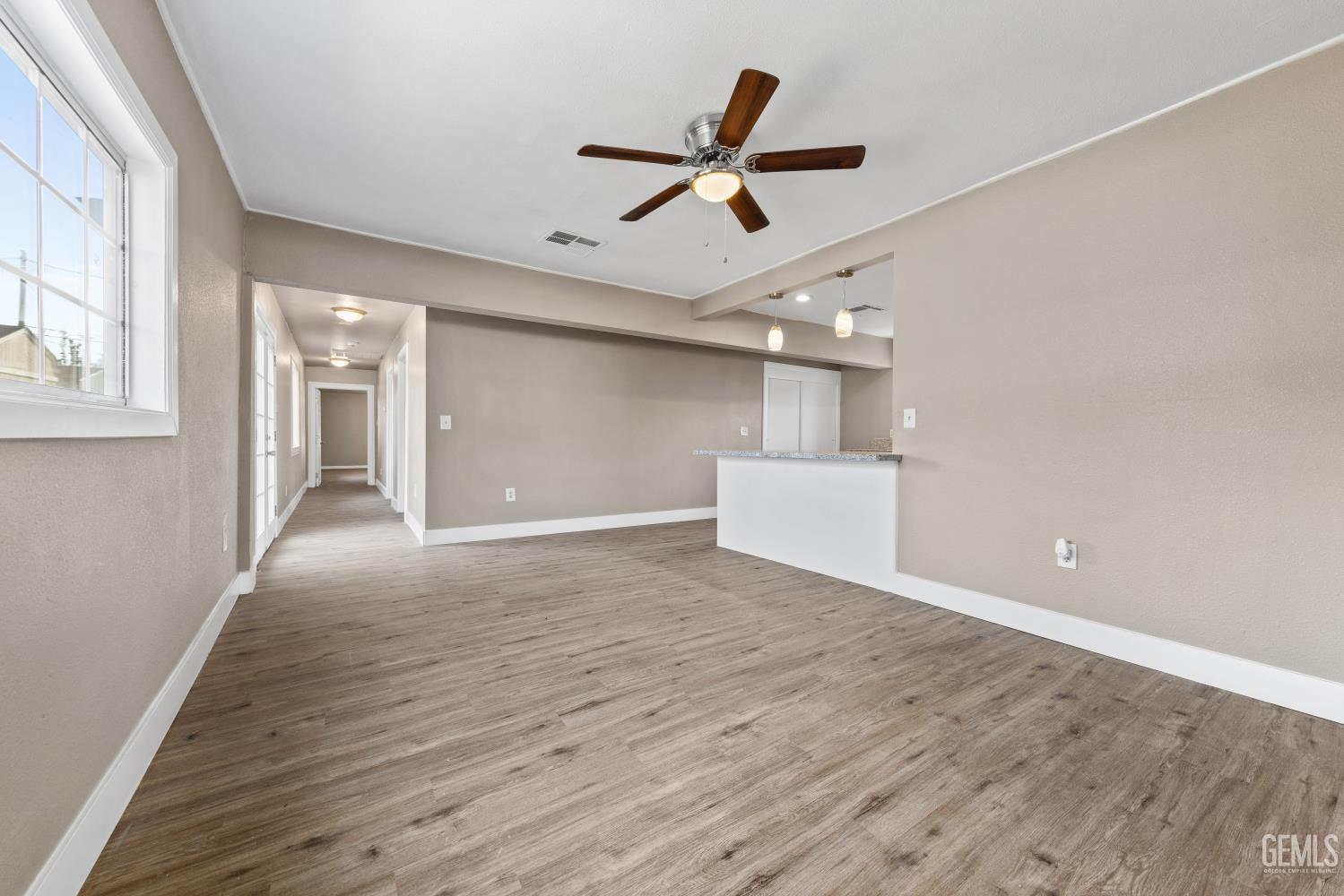 Undisclosed Address Bakersfield, CA 93305 - Photo 8 of 32 a view of empty room with wooden floor and ceiling fan