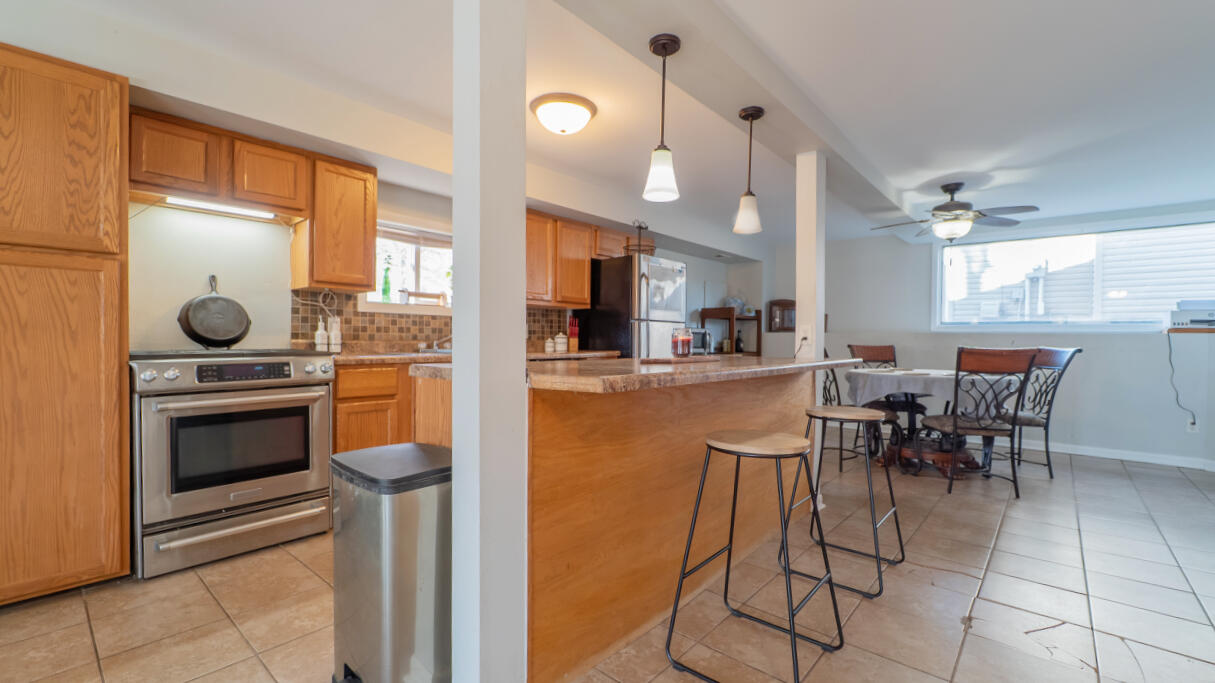 6318 Garfield Street Merrillville, IN 46410 - Photo 5 of 27 a kitchen with stainless steel appliances kitchen island granite countertop a table and chairs in it