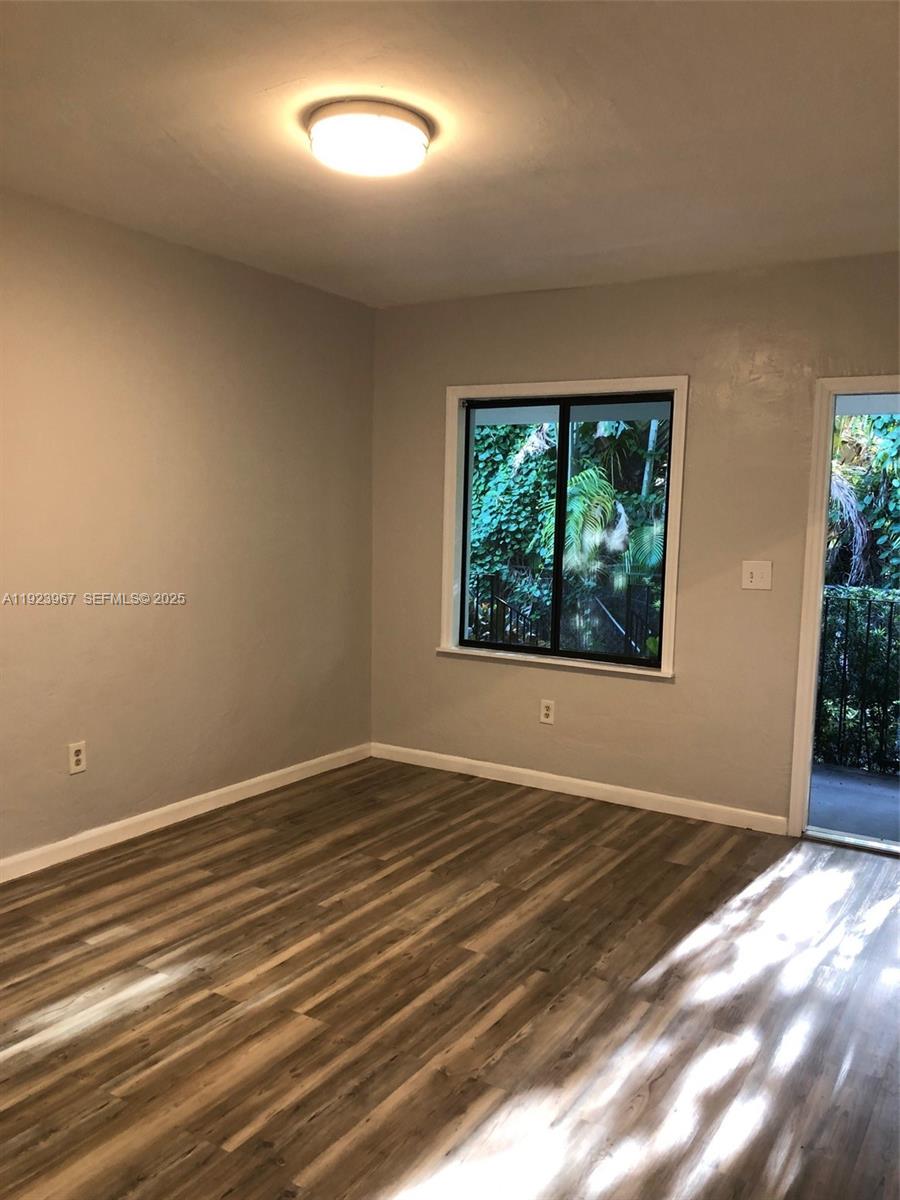 570 Northeast 69th Street, Unit 2 Miami, FL 33138 - Photo 16 of 21 an empty room with wooden floor and windows