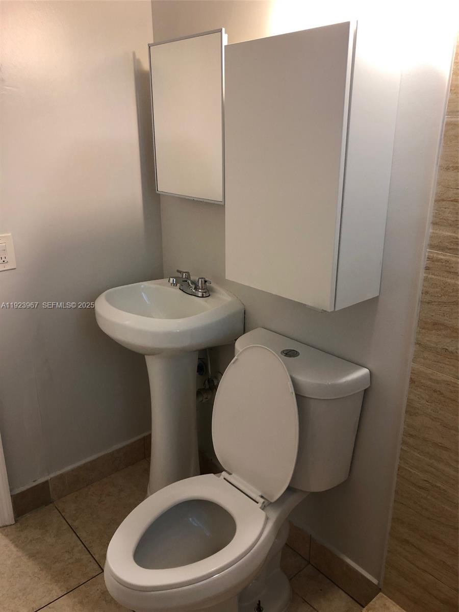 570 Northeast 69th Street, Unit 2 Miami, FL 33138 - Photo 10 of 21 a white toilet sitting next to a bathroom sink