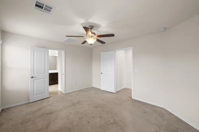 a view of an empty room with a ceiling fan