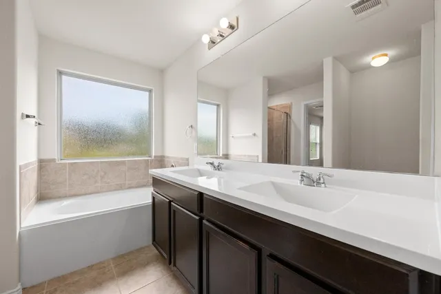 a bathroom with a tub sink and mirror