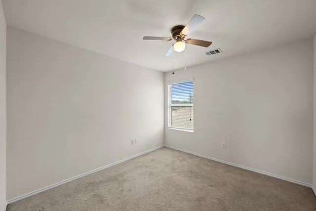 an empty room with a chandelier fan