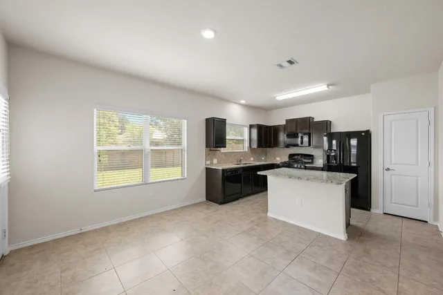 a large white kitchen with a stove a sink dishwasher and a refrigerator