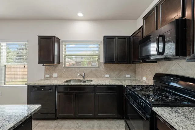 a kitchen with stainless steel appliances granite countertop a sink stove and cabinets