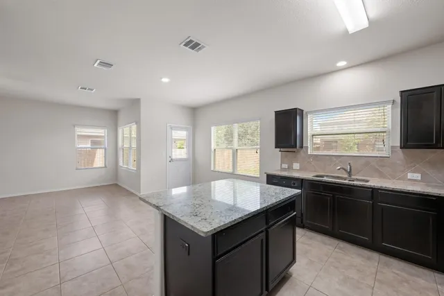 a kitchen with granite countertop a sink and a stove