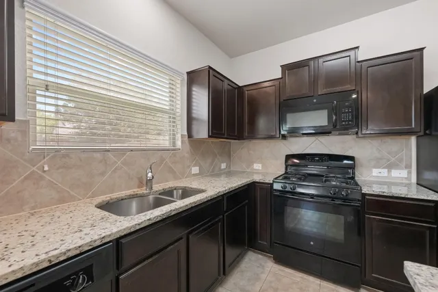 a kitchen with stainless steel appliances granite countertop a sink stove and microwave
