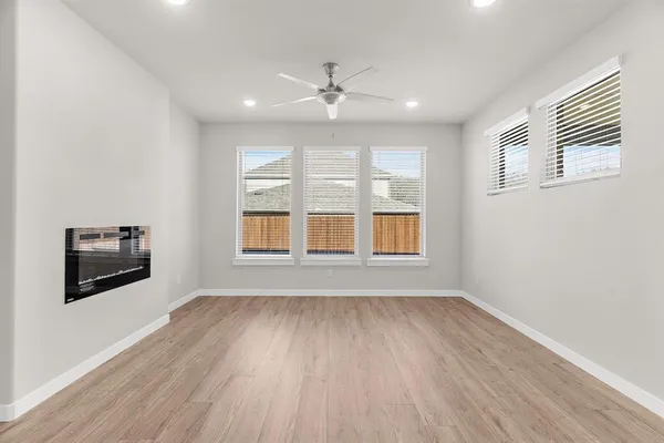 a view of an empty room with a window and wooden floor
