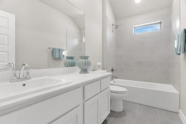 a view of a hallway with wooden floor and a bathroom