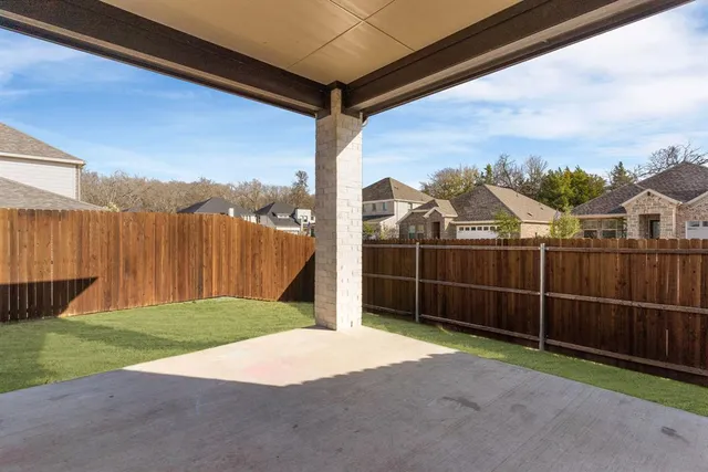 a backyard of a house with lots of green space and wooden fence
