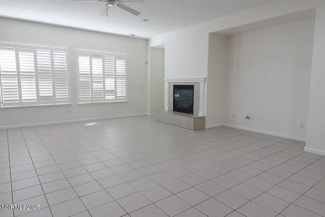 an empty room with windows and fireplace