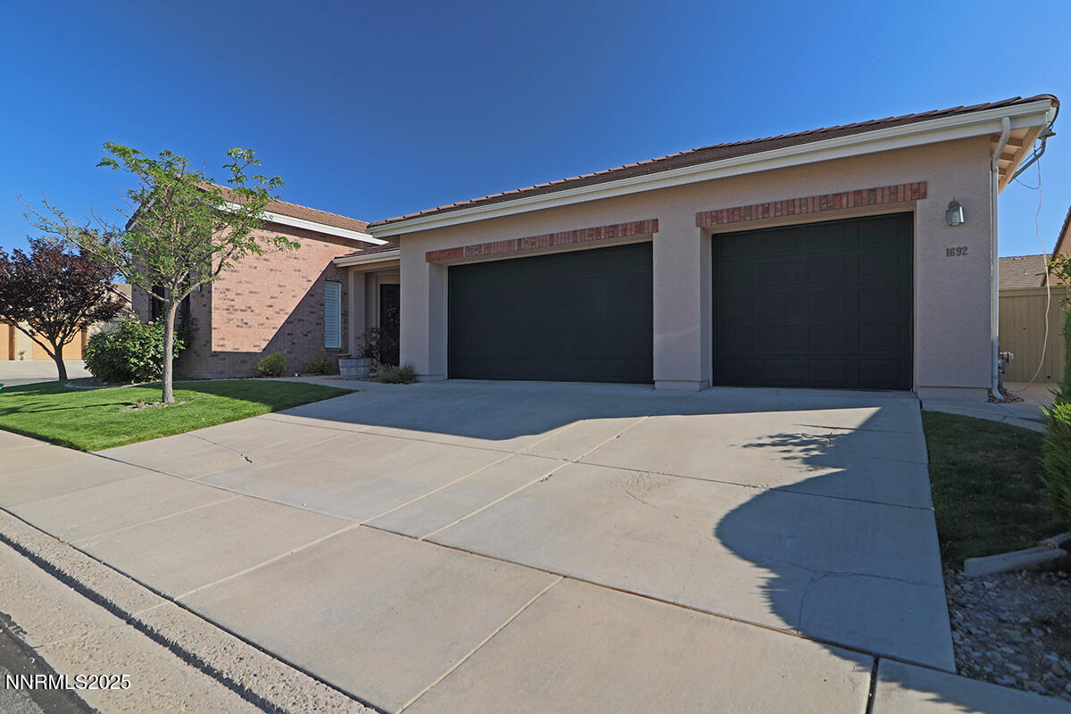 1692 Broadstone Way Reno, NV 89521 - Photo 3 of 31 a front view of a house with a yard and garage