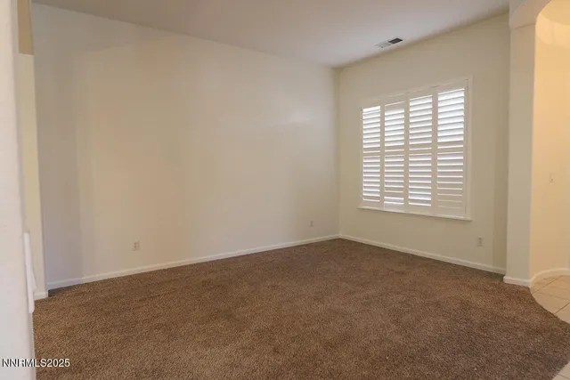an empty room with chandelier fan