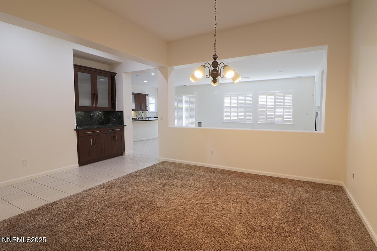 1692 Broadstone Way Reno, NV 89521 - Photo 9 of 31 an empty room with chandelier and wooden floor