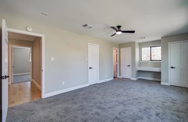 wooden floor in an empty room and a ceiling fan