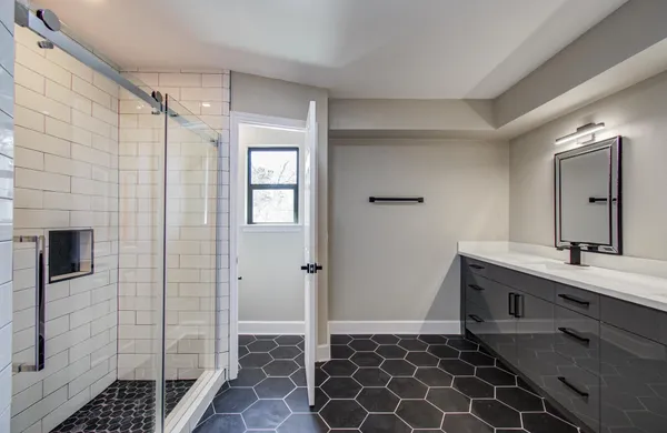 a bathroom with a double vanity sink mirror and shower