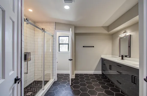 a bathroom with a double vanity sink mirror and shower
