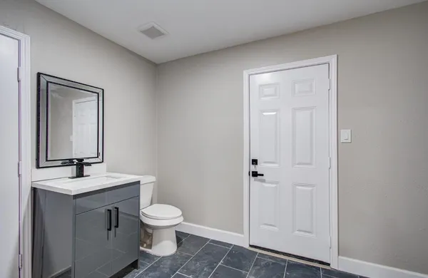 a bathroom with a toilet a sink and mirror