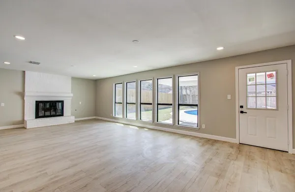 a view of an empty room with a window and fireplace