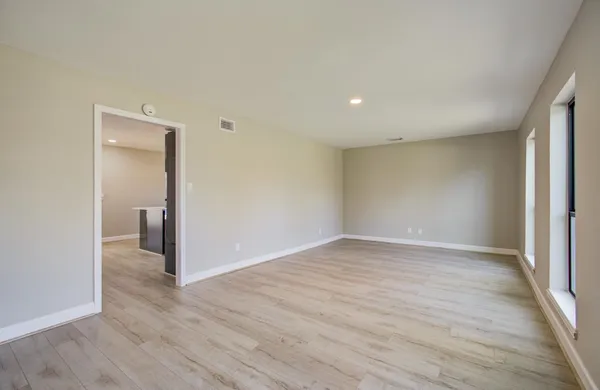 a view of an empty room with wooden floor