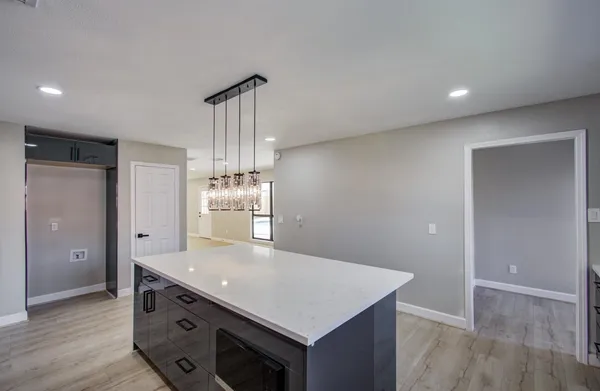 a kitchen with kitchen island white cabinets and refrigerator