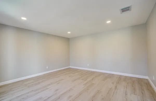a view of room with wooden floor and white walls