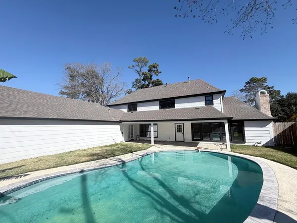 a view of a house with pool porch and a yard