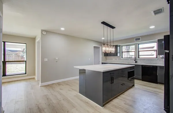 a kitchen with a stove and a wooden floor