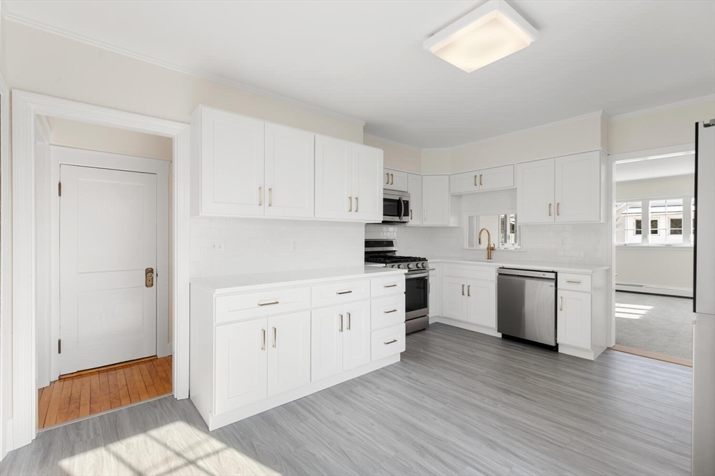 16 York Avenue Watertown, MA 02472 - Photo 12 of 34 a kitchen with a white cabinets and wooden floor