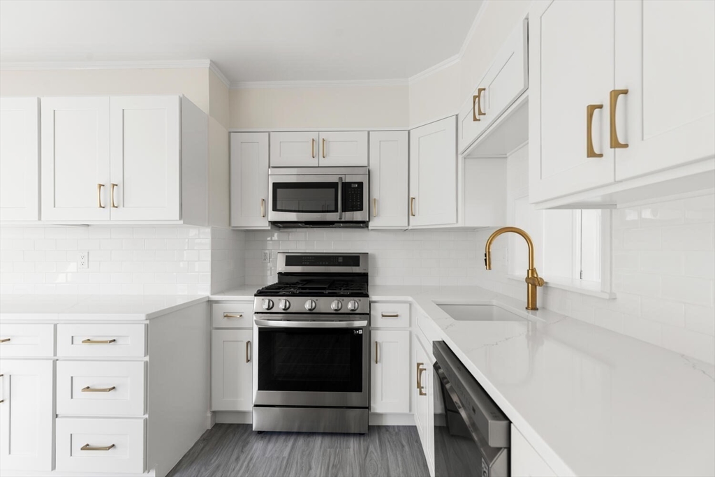 16 York Avenue Watertown, MA 02472 - Photo 13 of 34 a kitchen with white cabinets stainless steel appliances and sink
