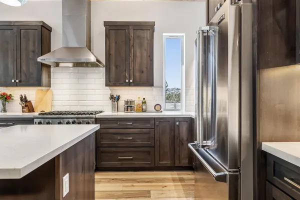 a kitchen with stainless steel appliances granite countertop a refrigerator and a stove