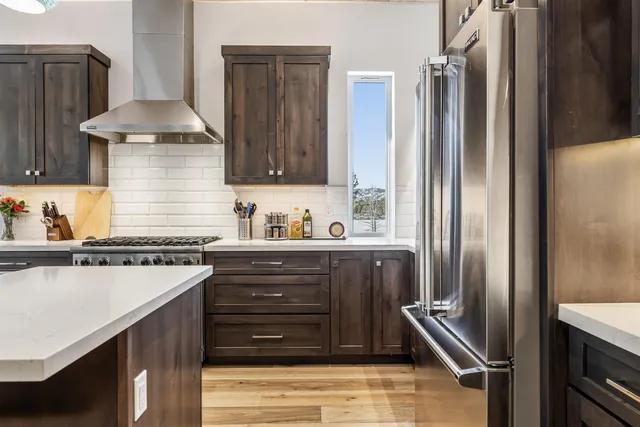 a kitchen with stainless steel appliances granite countertop a refrigerator and a stove