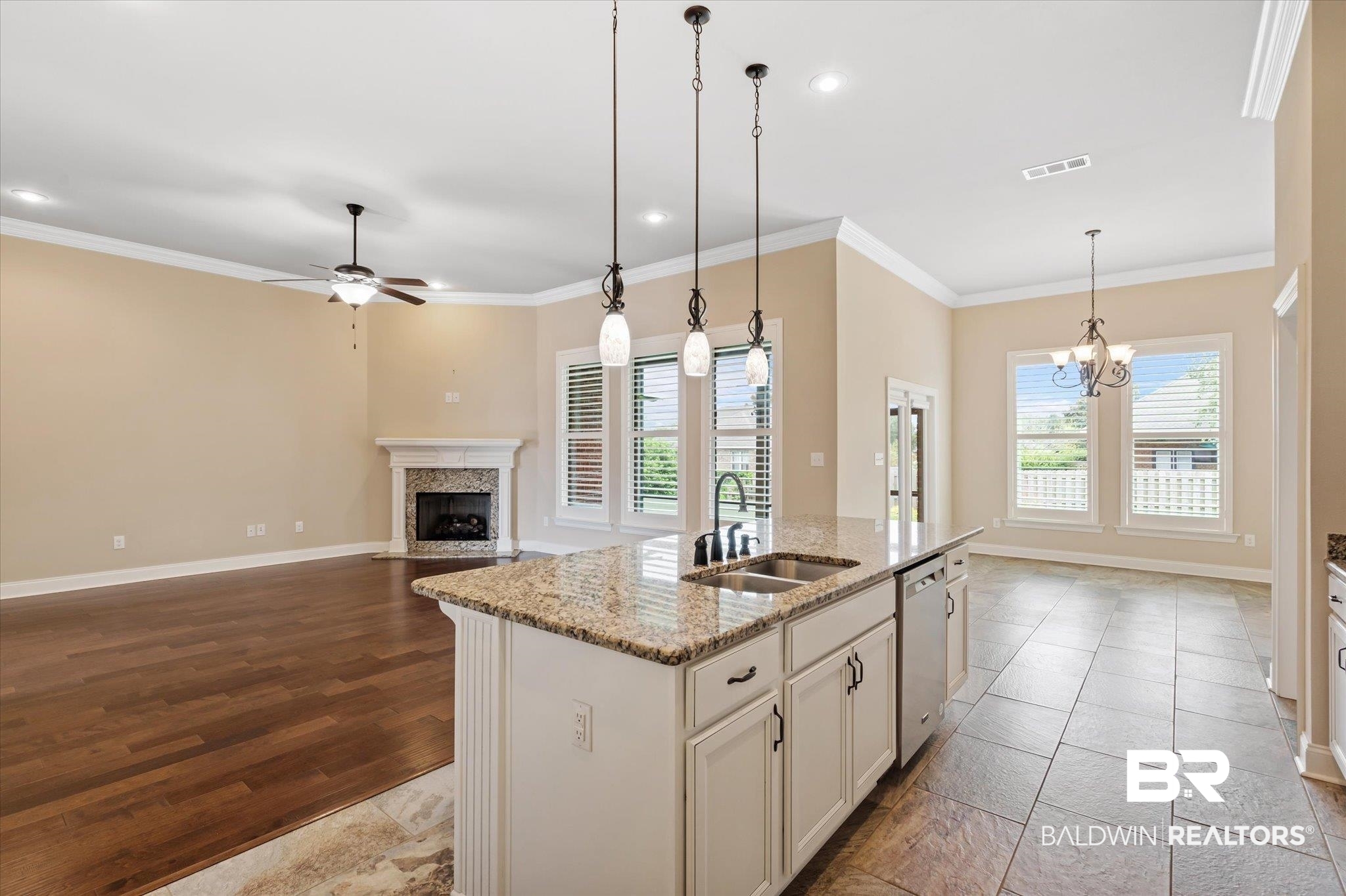 423 Breckin Drive Fairhope, AL 36532 - Photo 12 of 31 Kitchen with a high end fireplace, ceiling fan with notable chandelier, light hardwood / wood-style flooring, an island with sink, and sink