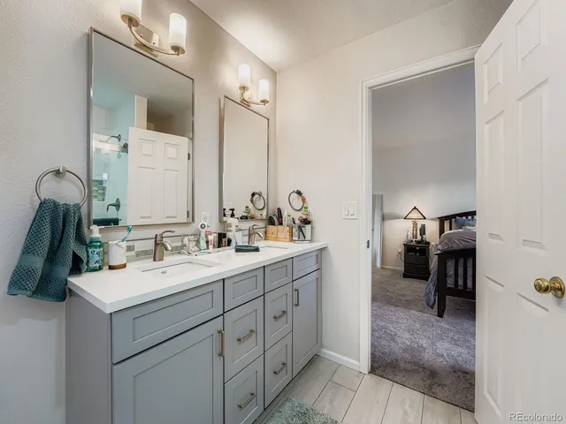 a en suite bathroom with a double vanity sink and a mirror