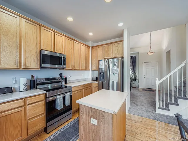 a kitchen with stainless steel appliances granite countertop a refrigerator stove microwave and sink