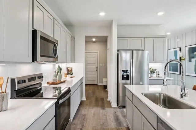 a kitchen with stainless steel appliances granite countertop a refrigerator sink and stove