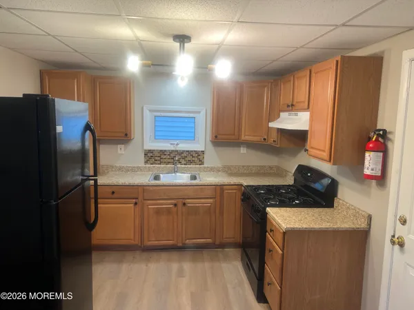 a kitchen with stainless steel appliances granite countertop a refrigerator a sink dishwasher a stove with wooden cabinets