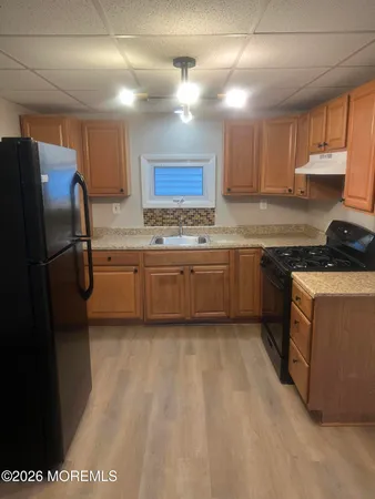 a kitchen with stainless steel appliances granite countertop a refrigerator a sink dishwasher a stove with wooden cabinets