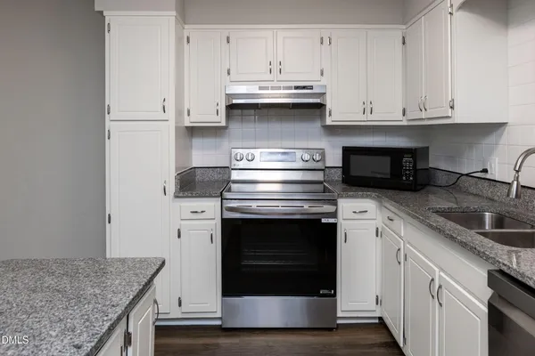 a kitchen with stainless steel appliances granite countertop a refrigerator sink and cabinets