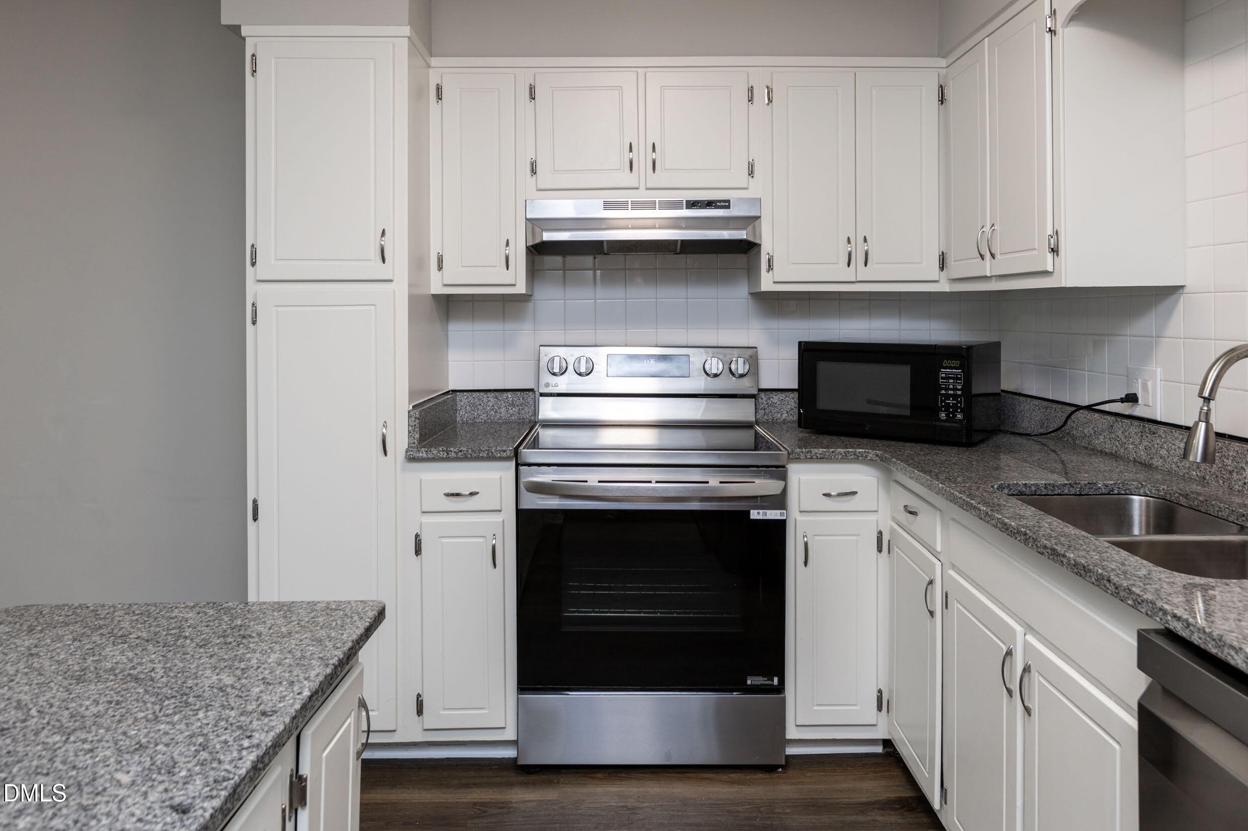 5036 Flint Ridge Place Raleigh, NC 27609 - Photo 11 of 21 a kitchen with granite countertop white cabinets and a stove