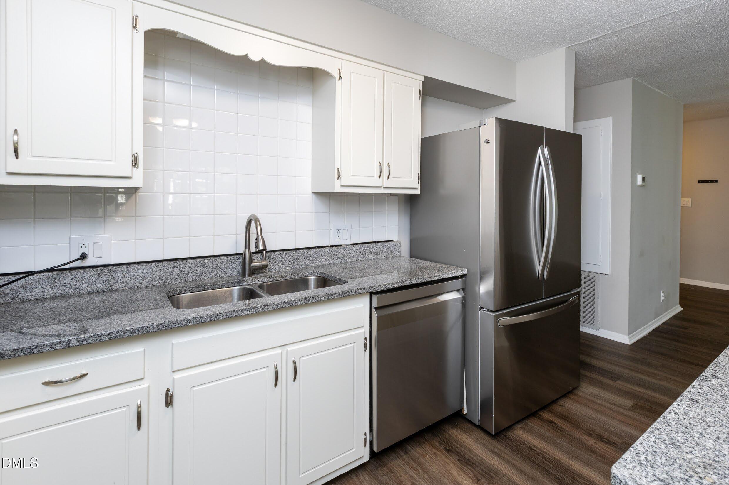 5036 Flint Ridge Place Raleigh, NC 27609 - Photo 12 of 21 a kitchen with stainless steel appliances granite countertop a refrigerator sink and cabinets