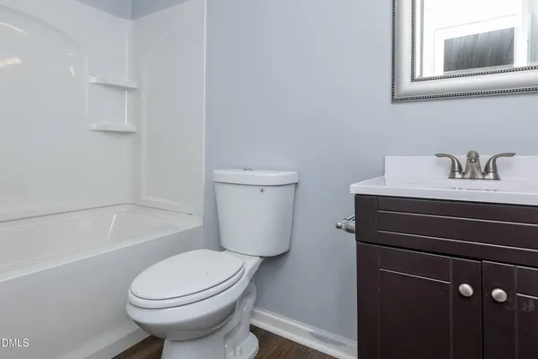 a white toilet sitting next to a bath tub