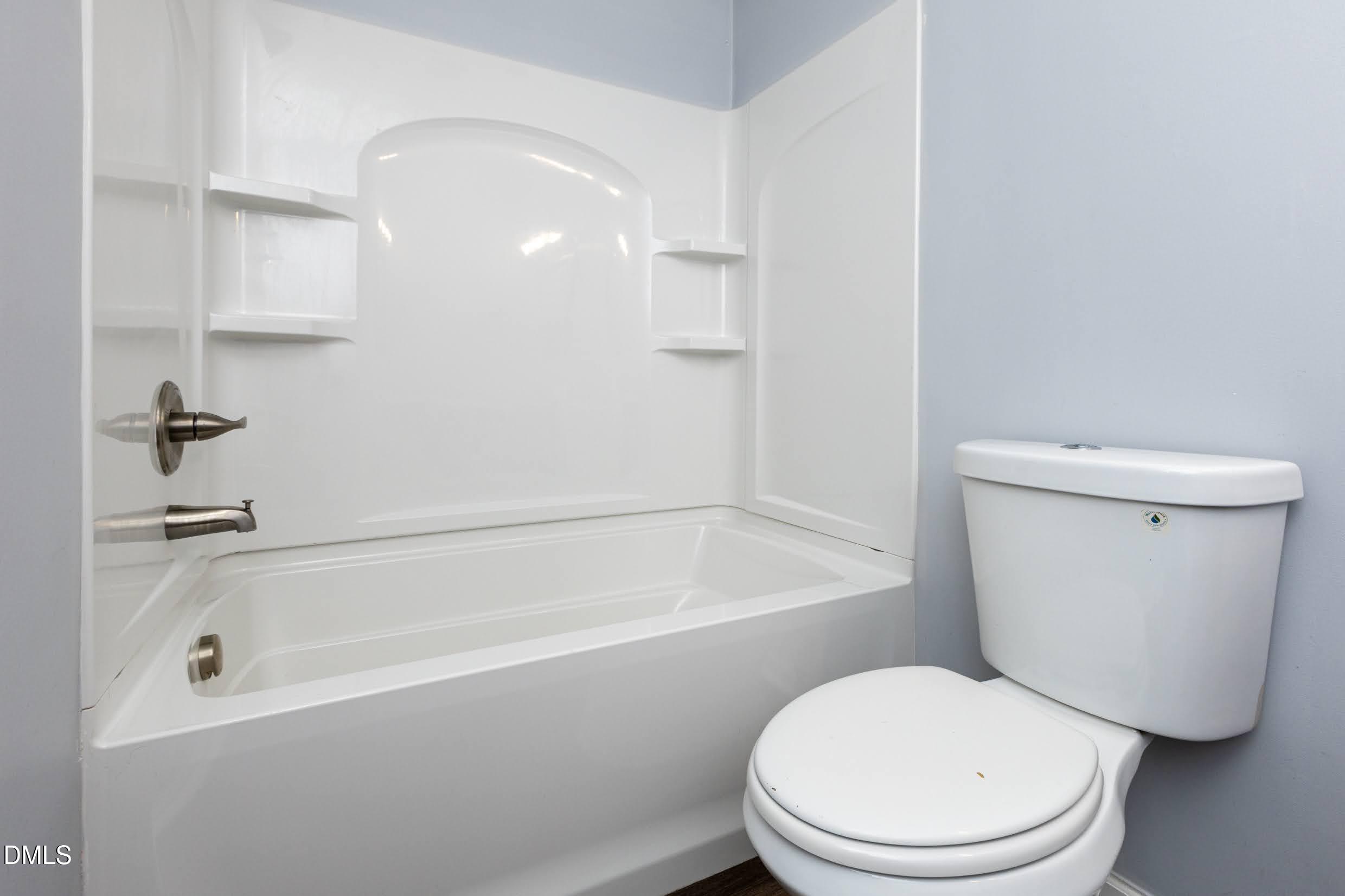5036 Flint Ridge Place Raleigh, NC 27609 - Photo 17 of 21 a white toilet sitting next to a bath tub