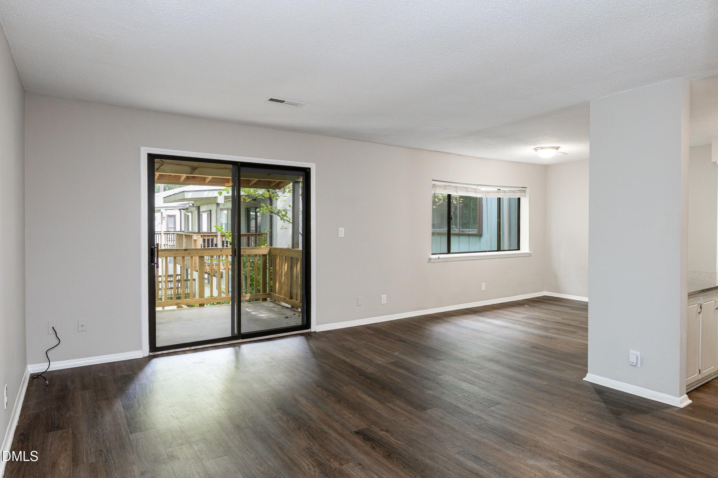 5036 Flint Ridge Place Raleigh, NC 27609 - Photo 5 of 21 an empty room with wooden floor and windows